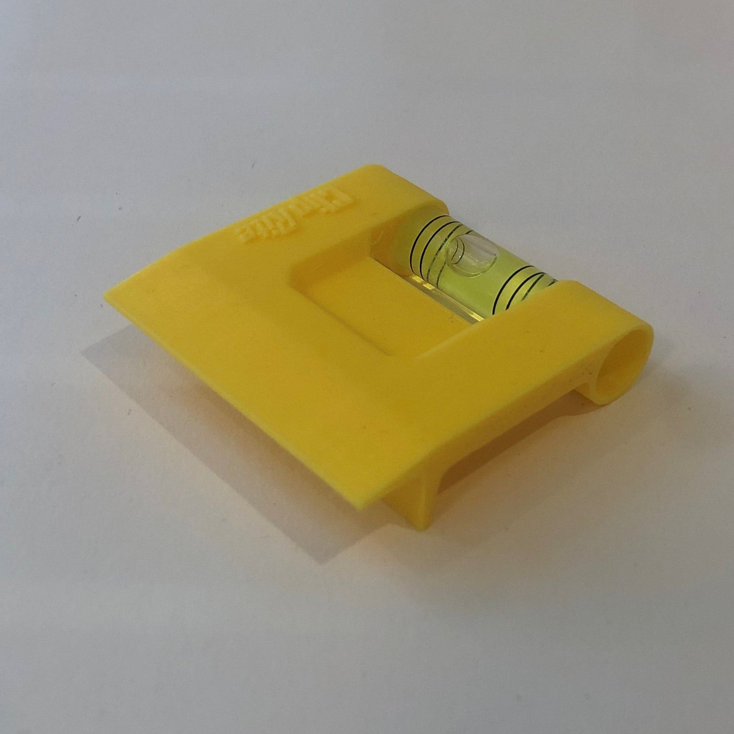 Yellow hands-free plastic clip-on level, designed for easy attachment to surfaces, featuring a built-in bubble vial for precise alignment during leveling tasks for floating picture frames