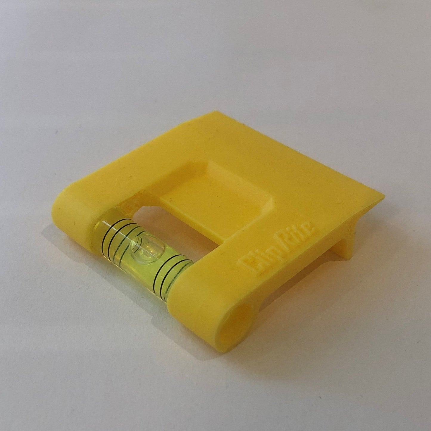 Yellow hands-free plastic clip-on level, designed for easy attachment to surfaces, featuring a built-in bubble vial for precise alignment during leveling tasks for flaoting picture frames