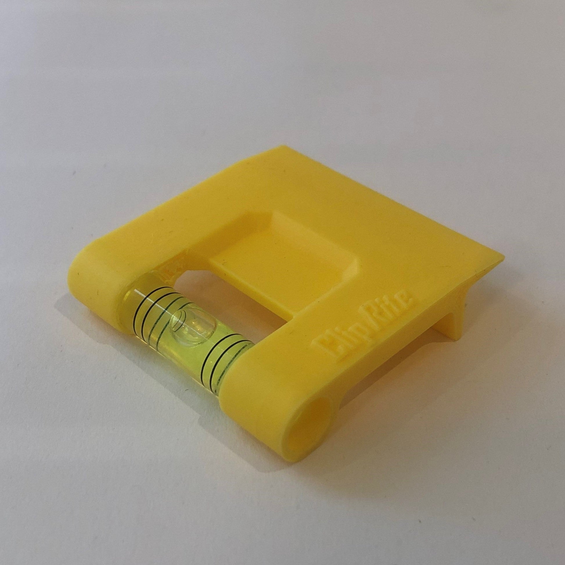 Yellow hands-free plastic clip-on level, designed for easy attachment to surfaces, featuring a built-in bubble vial for precise alignment during leveling tasks for flaoting picture frames